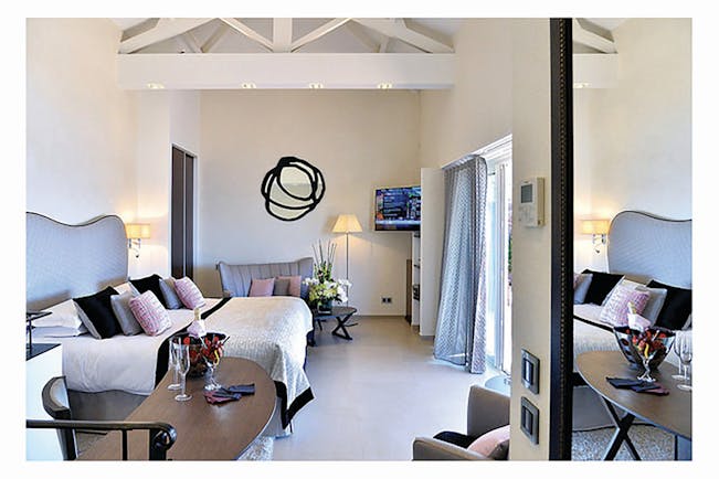 Hotel La Perouse Nice sea view bedroom with black and white mirror a sofa and a desk with wine 