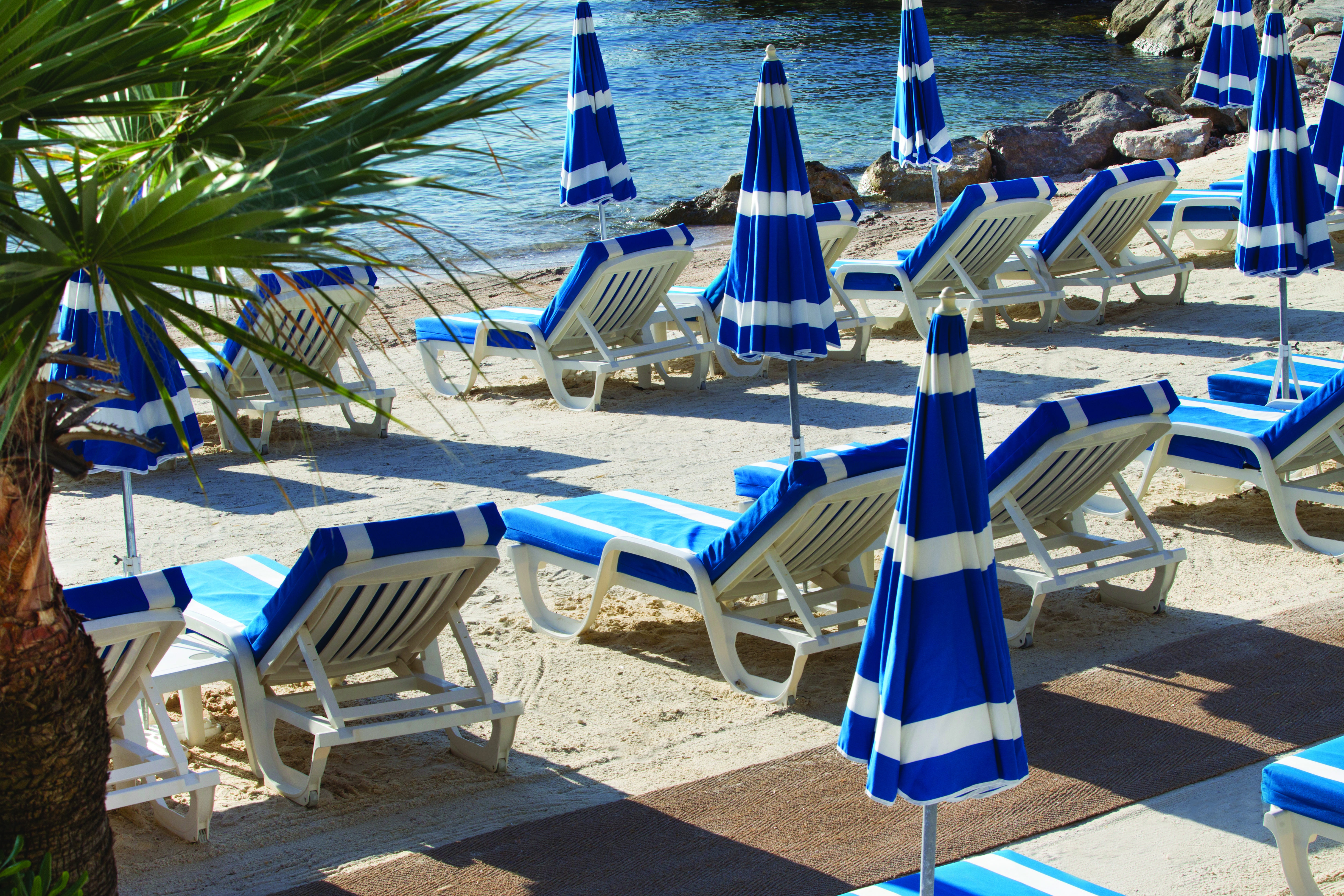 Royal Riviera Cote d'Azur beach sea blue and white sun loungers and umbrellas 