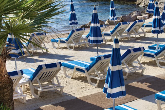 Royal Riviera Cote d'Azur beach sea blue and white sun loungers and umbrellas 