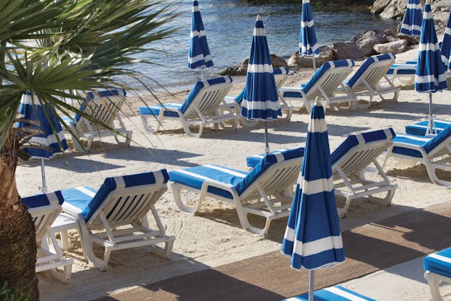 Royal Riviera Cote d'Azur beach sea blue and white sun loungers and umbrellas 