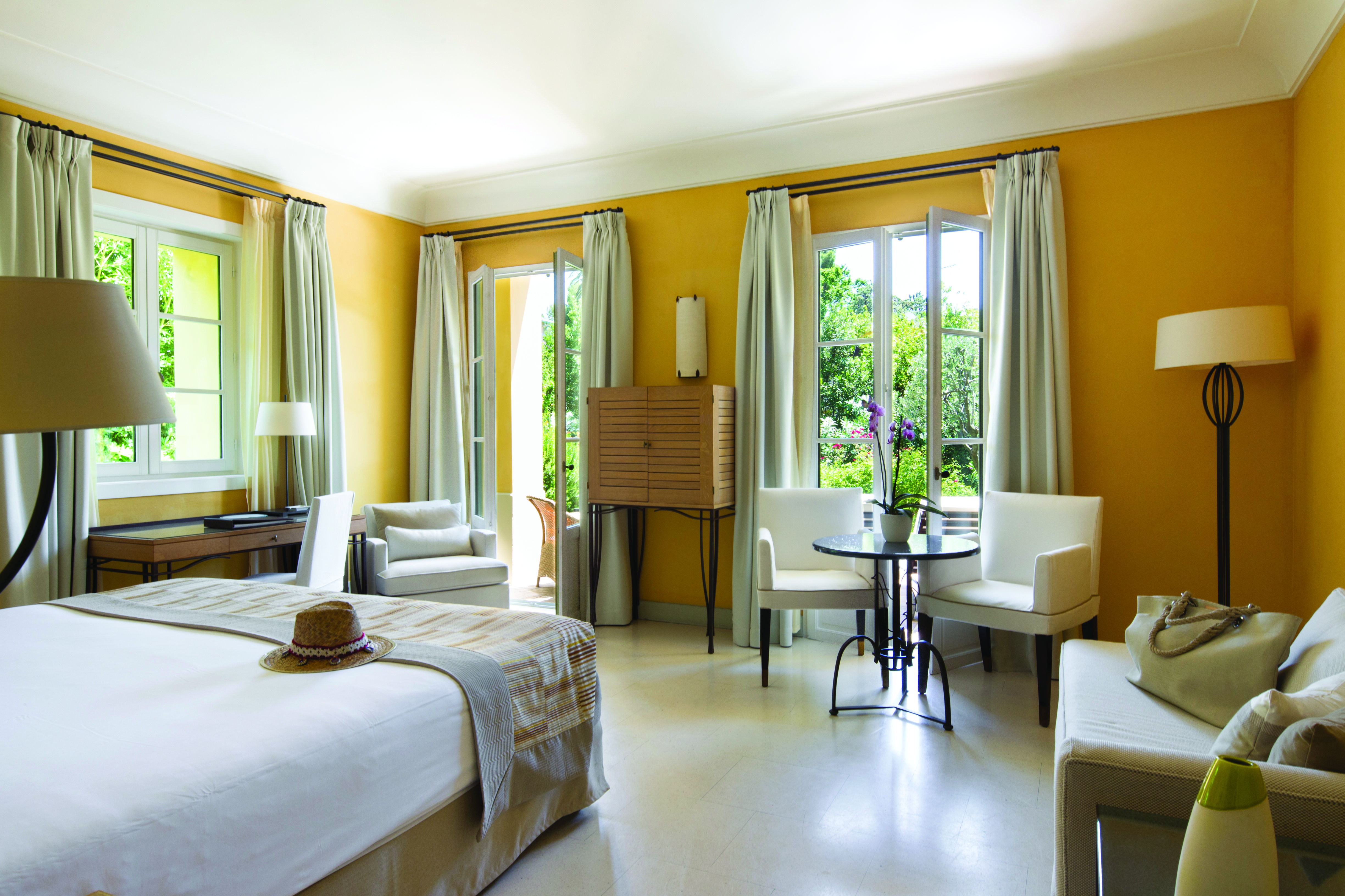 Royal Riviera Cote d'Azur orangerie deluxe yellow bedroom with sofa and armchair table and chairs and writing desk
