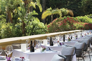 Royal Riviera Cote d'Azur garden view terrace tables with wine glasses overlooking garden and flowers