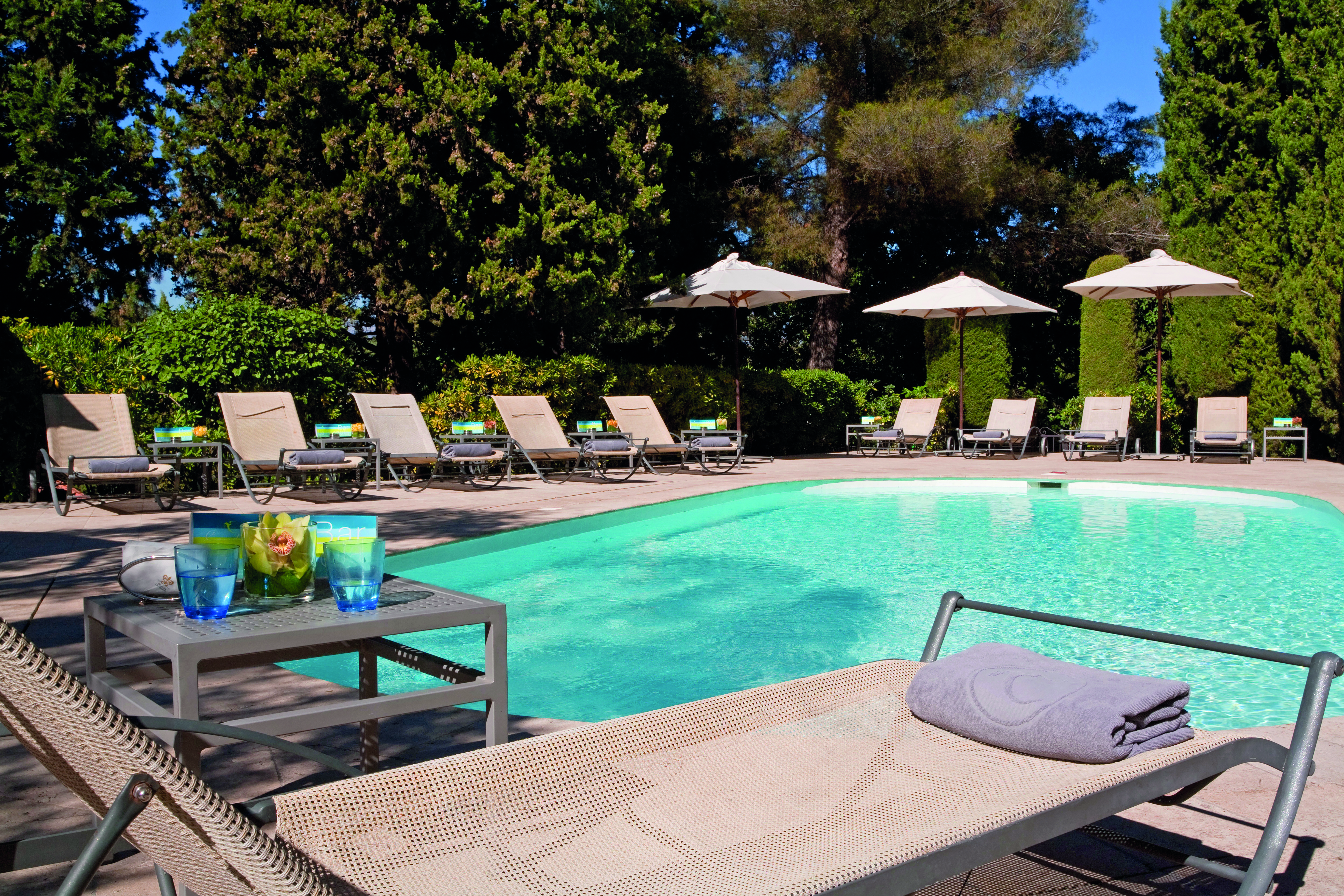 Le Mas Candille Cote d'Azur outside pool sun loungers and umbrellas