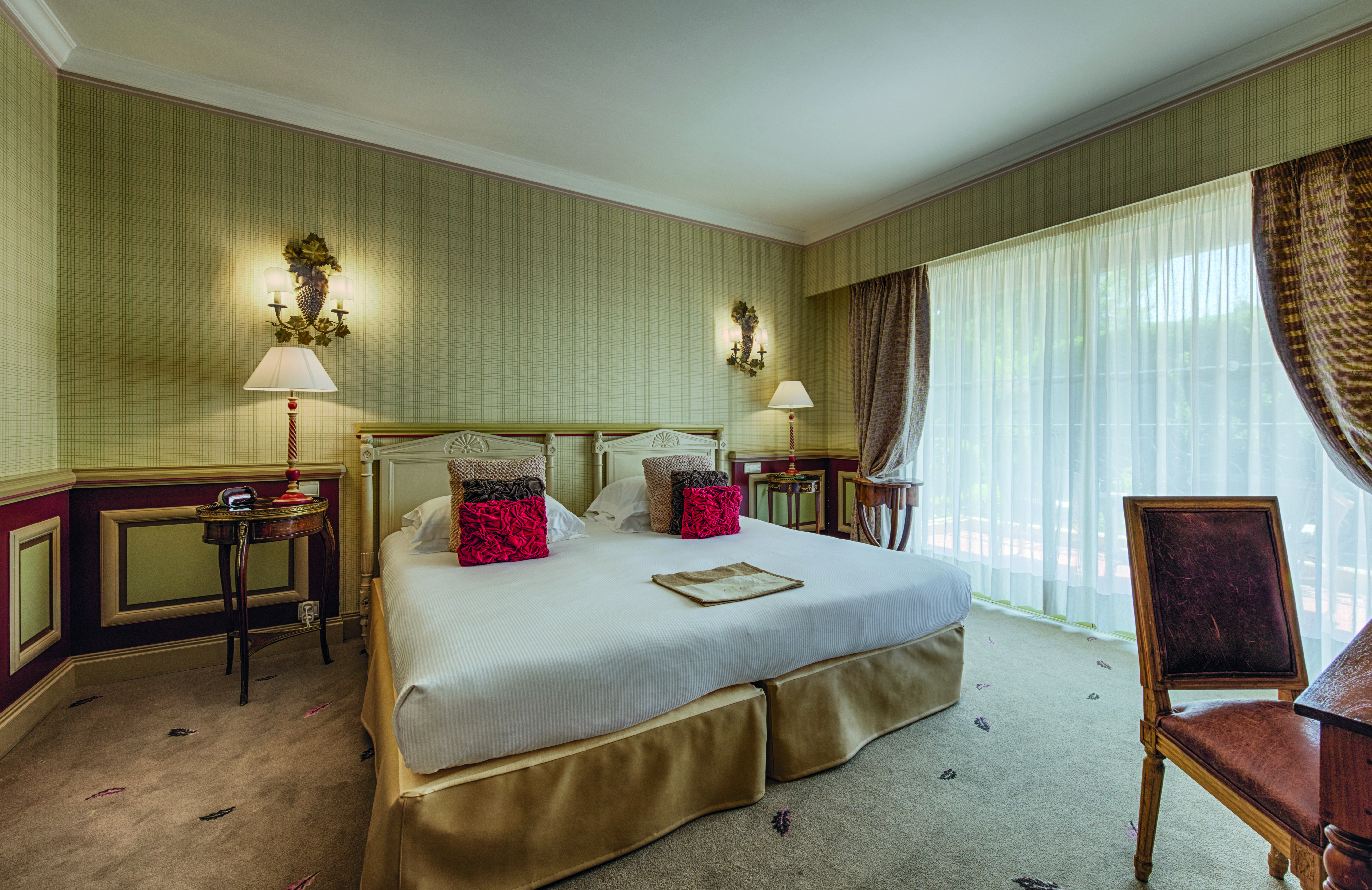 Le Mas Candille Cote d'Azur superior bedroom red panelled walls and bedside tables and a desk