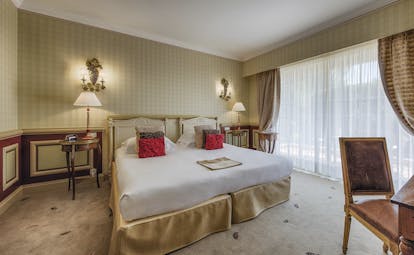 Le Mas Candille Cote d'Azur superior bedroom red panelled walls and bedside tables and a desk