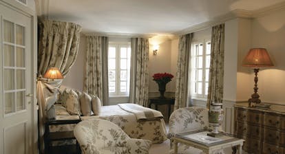Le Saint Paul Cote d'Azur deluxe bedroom with drapes above bed with cream and grey floral pattern