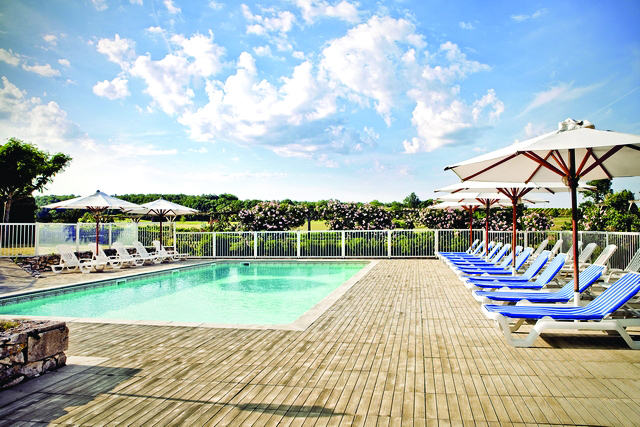 Chateau des Vigiers Dordogne outdoor heated pool with sun loungers and umbrellas