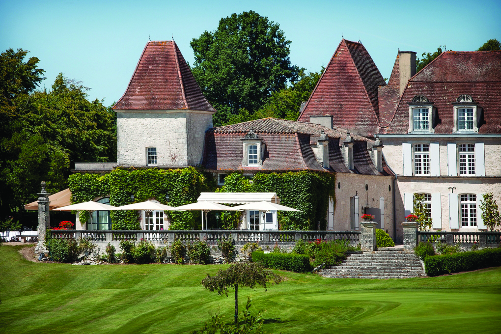 Chateau des Vigiers Dordogne outdoor large building foliage covered wall seating area with large white umbrellas