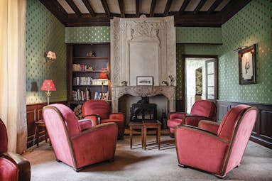 Chateau des Vigiers Dordogne lounge area with large fireplace and armchairs