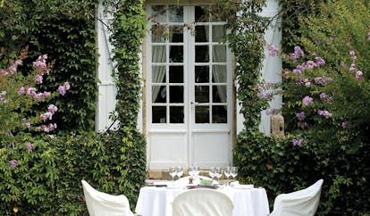 Le Vieux Logis Dordogne outdoor dining area in a garden with purple flowers