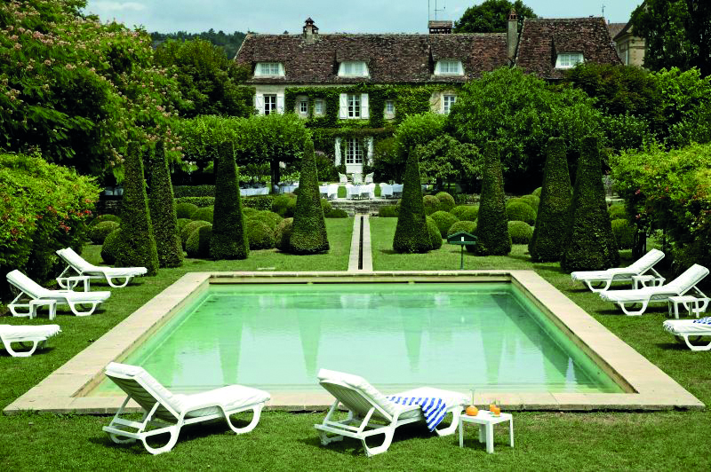 Le Vieux Logis Dordogne outdoor swimming pool sun loungers and topiary trees