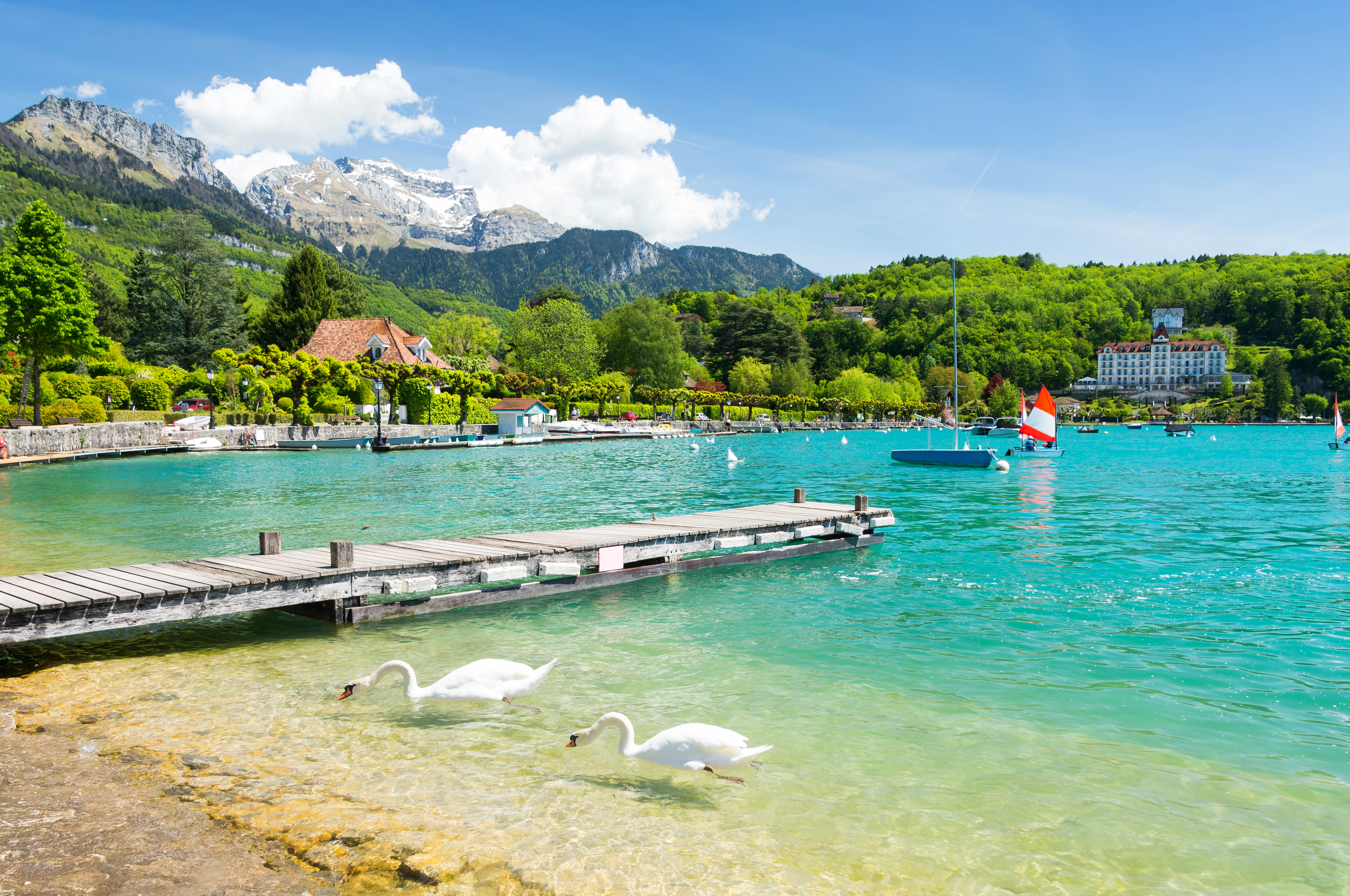 turquoise lake with swans and jetty in the French Alps