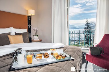 L'Imperial Palace Alps classic bedroom with a breakfast tray lake view