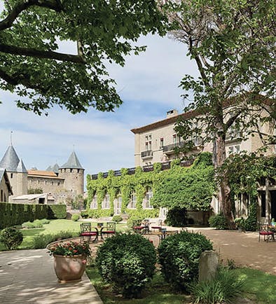 Hotel de la Cite Carcassonne Languedoc Roussillon exterior chateau and white building garden and seating area