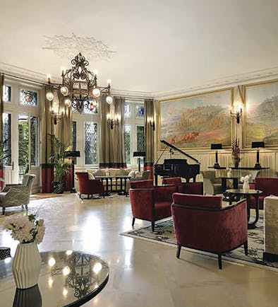 Hotel de la Cite Carcassonne Languedoc Roussillon lounge area with armchairs a grand piano and paintings