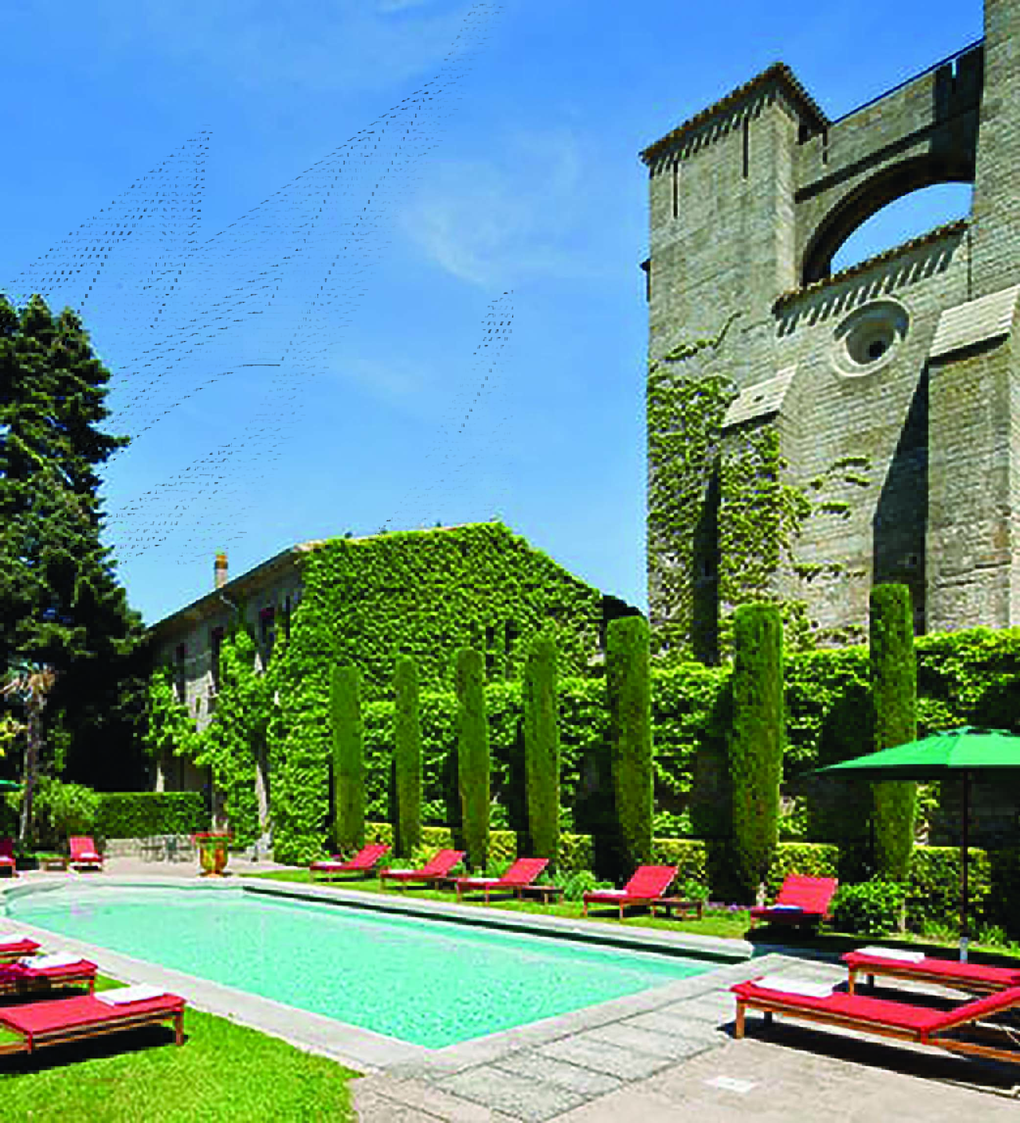 Hotel de la Cite Carcassonne Languedoc Roussillon pool with sun loungers umbrellas and topiary bushes