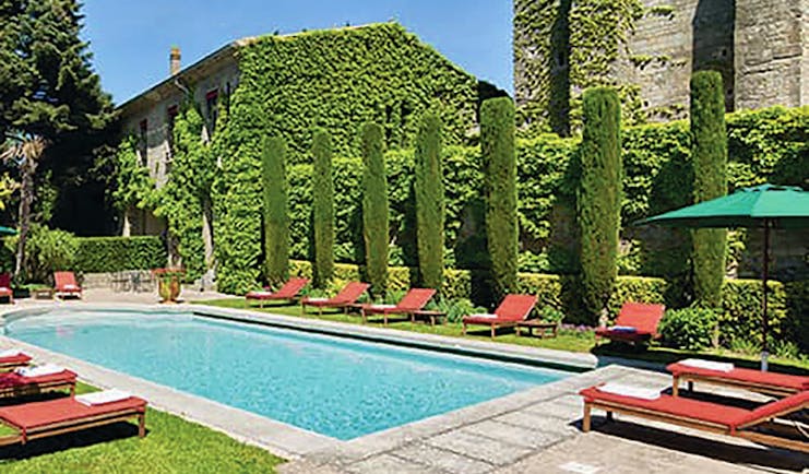 Hotel de la Cite Carcassonne Languedoc Roussillon pool with sun loungers umbrellas and topiary bushes