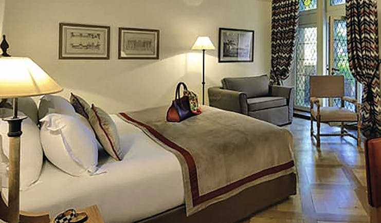 Hotel de la Cite Carcassonne Languedoc Roussillon suite bedroom with armchair chair and stained-glass window