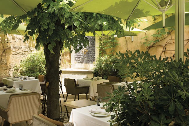 Maison d'Uzes Languedoc Roussillon patio terrace dining courtyard patio with trees and umbrellas