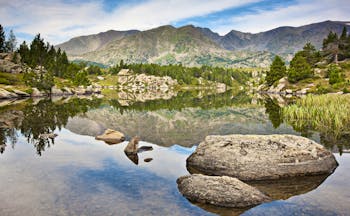 Mountain lake with pine trees and rocks at Carlit Peak in French Catalonia