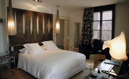 Le Domaine de Verchant Languedoc Roussillon bedroom with wooden bedhead glass desk and chair