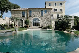 Le Domaine de Verchant Languedoc Roussillon swimming pool large stone building palm trees gardens