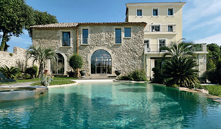 Le Domaine de Verchant Languedoc Roussillon swimming pool large stone building palm trees gardens