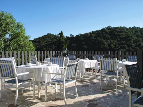 Relais des Chartreuses Languedoc Roussillon terrace area with several tables and chairs surrounded by trees