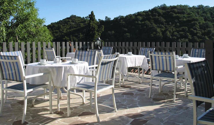 Relais des Chartreuses Languedoc Roussillon terrace area with several tables and chairs surrounded by trees