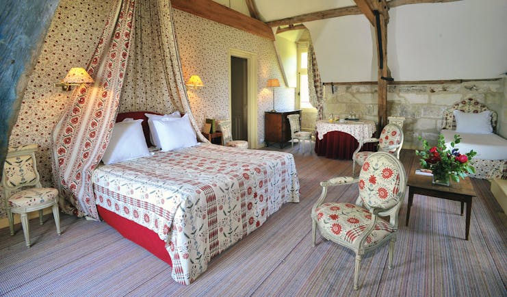 Chateau de la Bourdaisiere Loire Valley large bedroom with exposed wooden beams large bed single bed chairs and a table