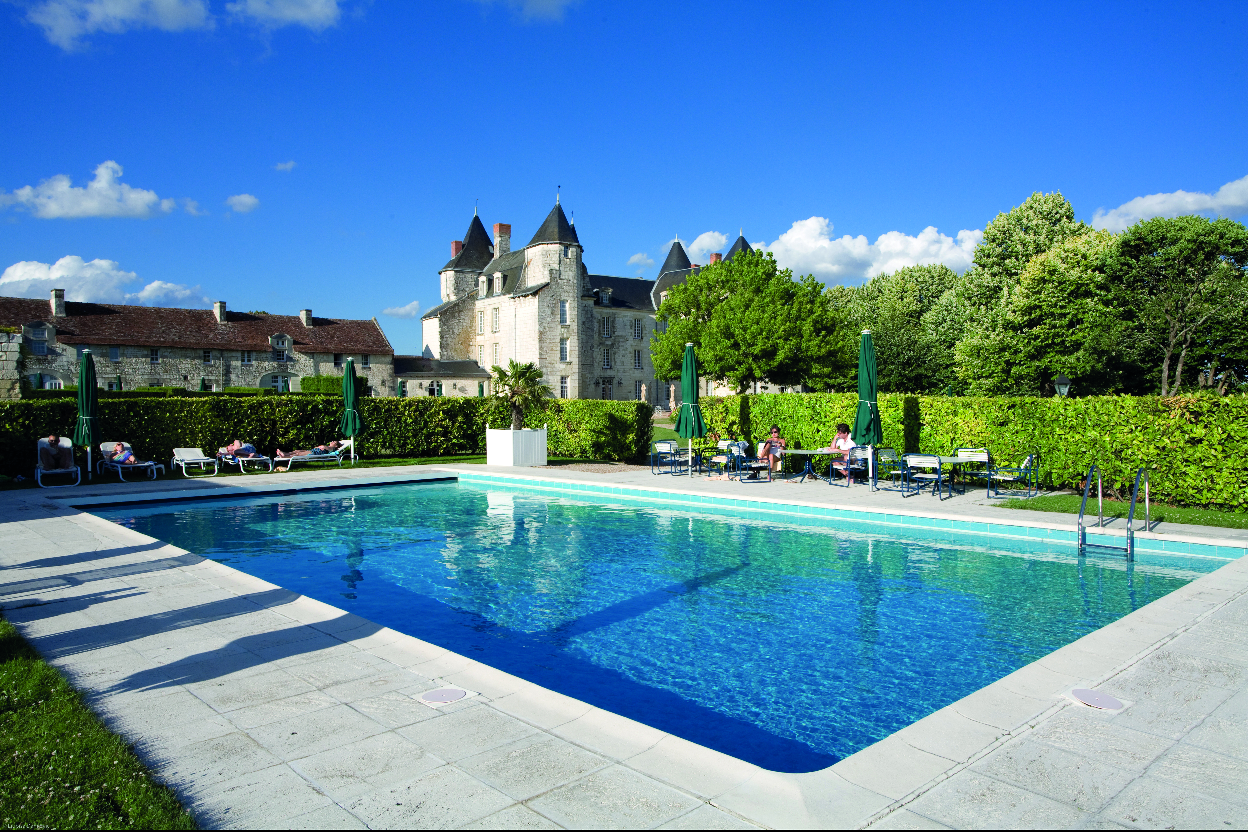Chateau de Marcay Loire Valley outdoor swimming pool with sun loungers and umbrellas 
