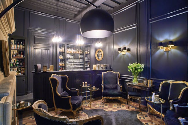 Chateau Noirieux Loire Valley bar area with dark blue walls dark blue and gold chairs and fireplace