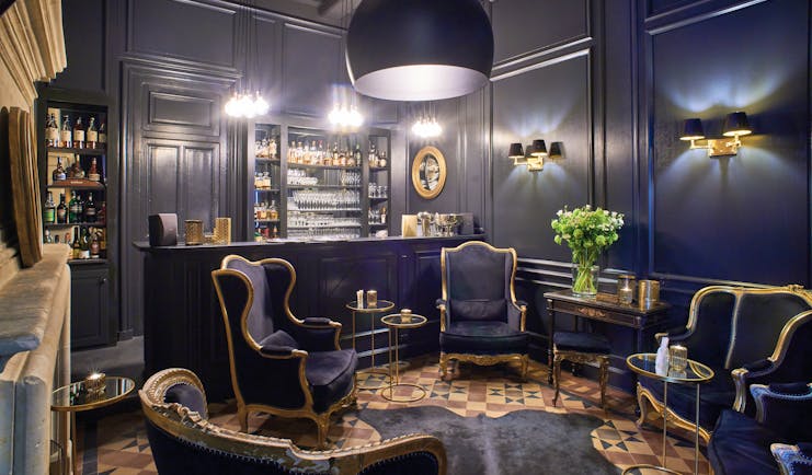 Chateau Noirieux Loire Valley bar area with dark blue walls dark blue and gold chairs and fireplace