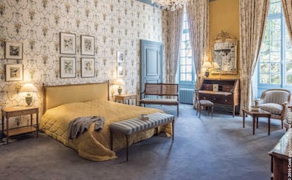 Chateau Noirieux Loire Valley deluxe bedroom with patterned wallpaper and chandelier