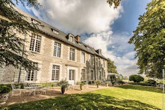 Chateau Noirieux Loire Valley exterior shot stone chateau with large windows and white metal chairs 