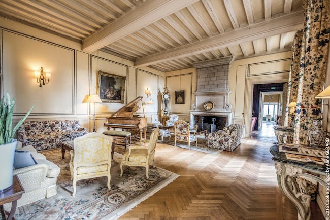 Chateau Noirieux Loire Valley salon lounge area with armchairs grand piano and large fireplace