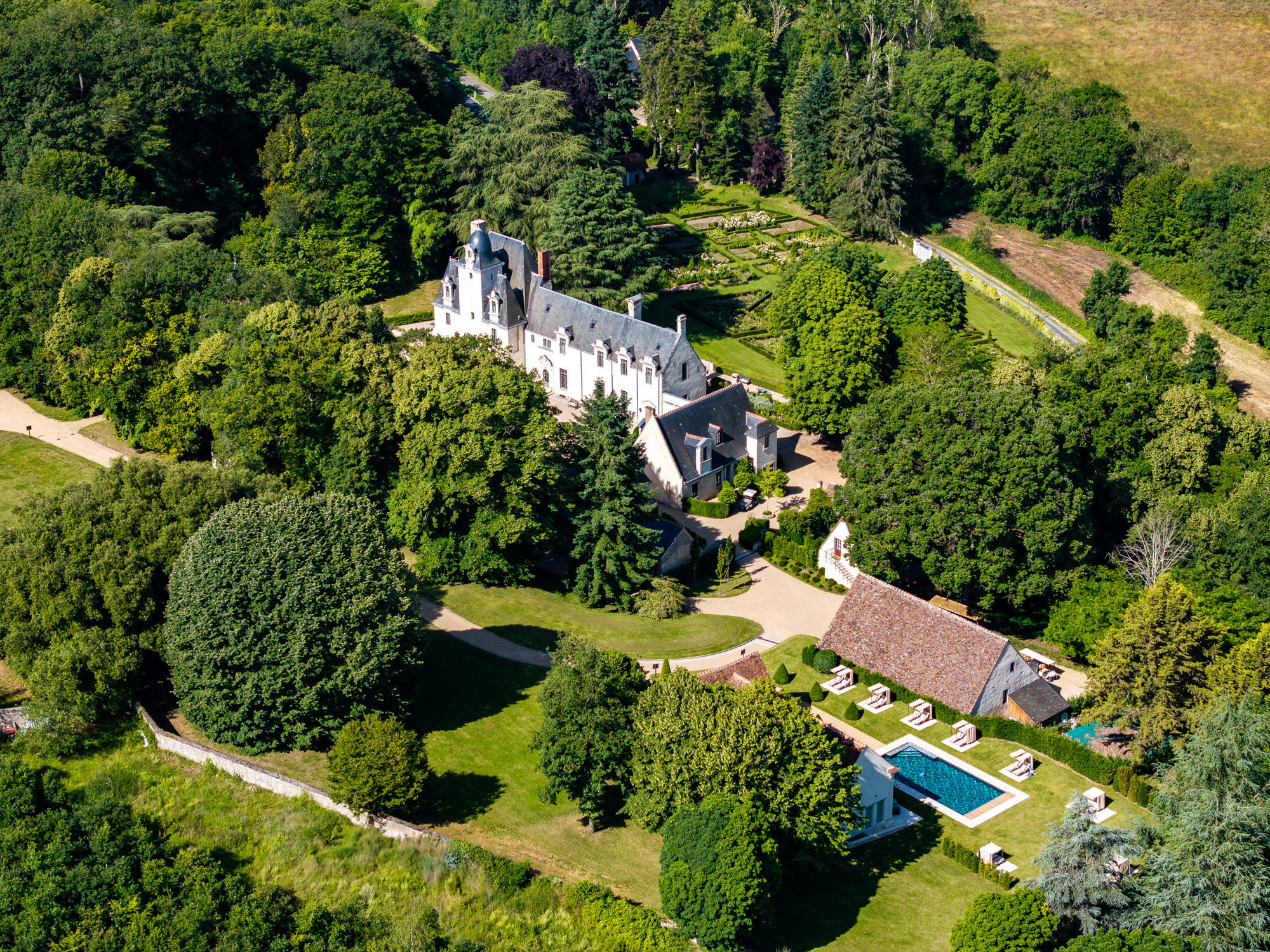 Chateau Louise de la Valliere aerial shot, showing the castle emerging from the lawns and trees of the hotel estate