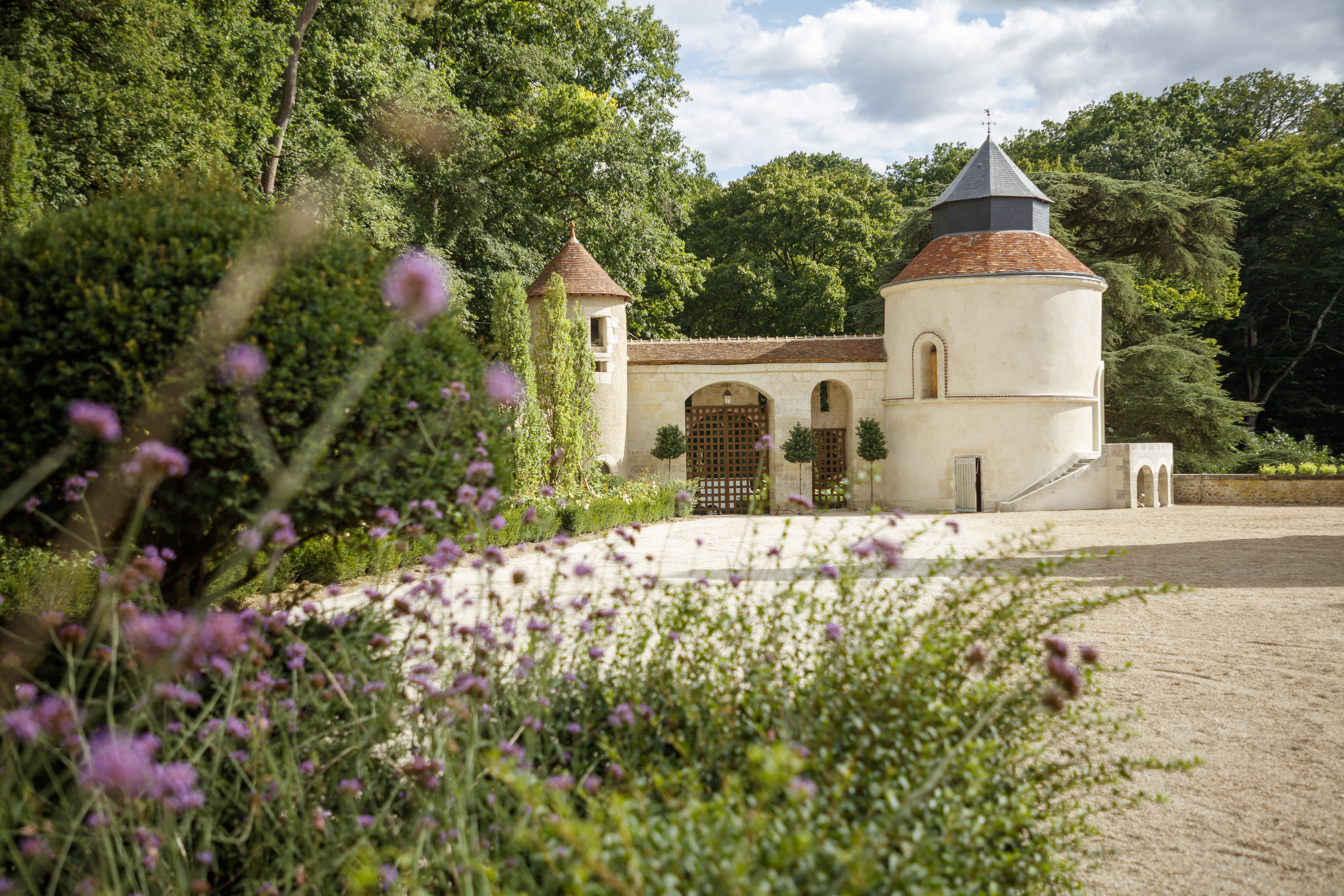 Chateau Louise de la Valliere entrance, with white-washed stone arched gate and a large gravel drive