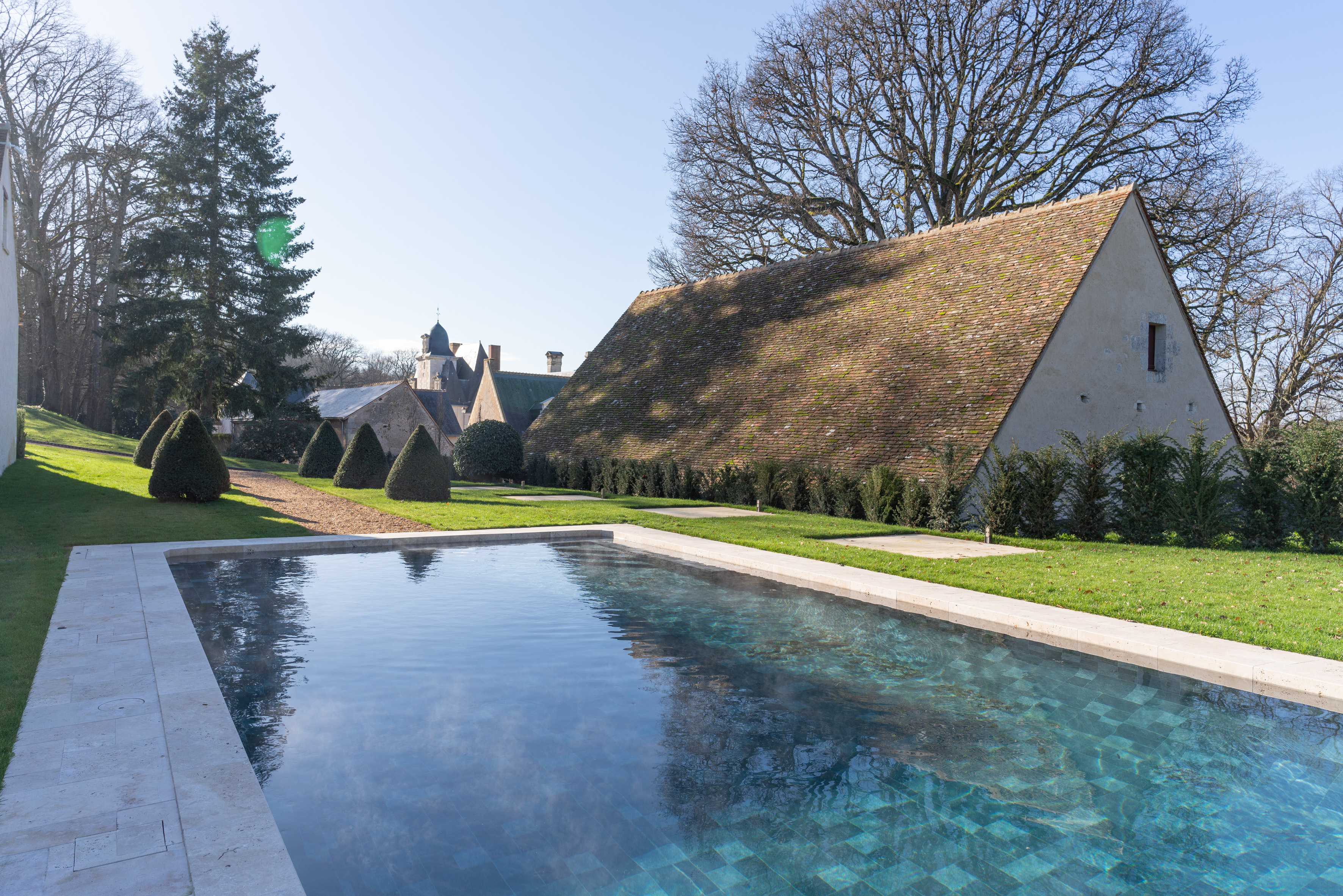Chateau Louise de la Valliere poolside, with out building and manicured shrubs