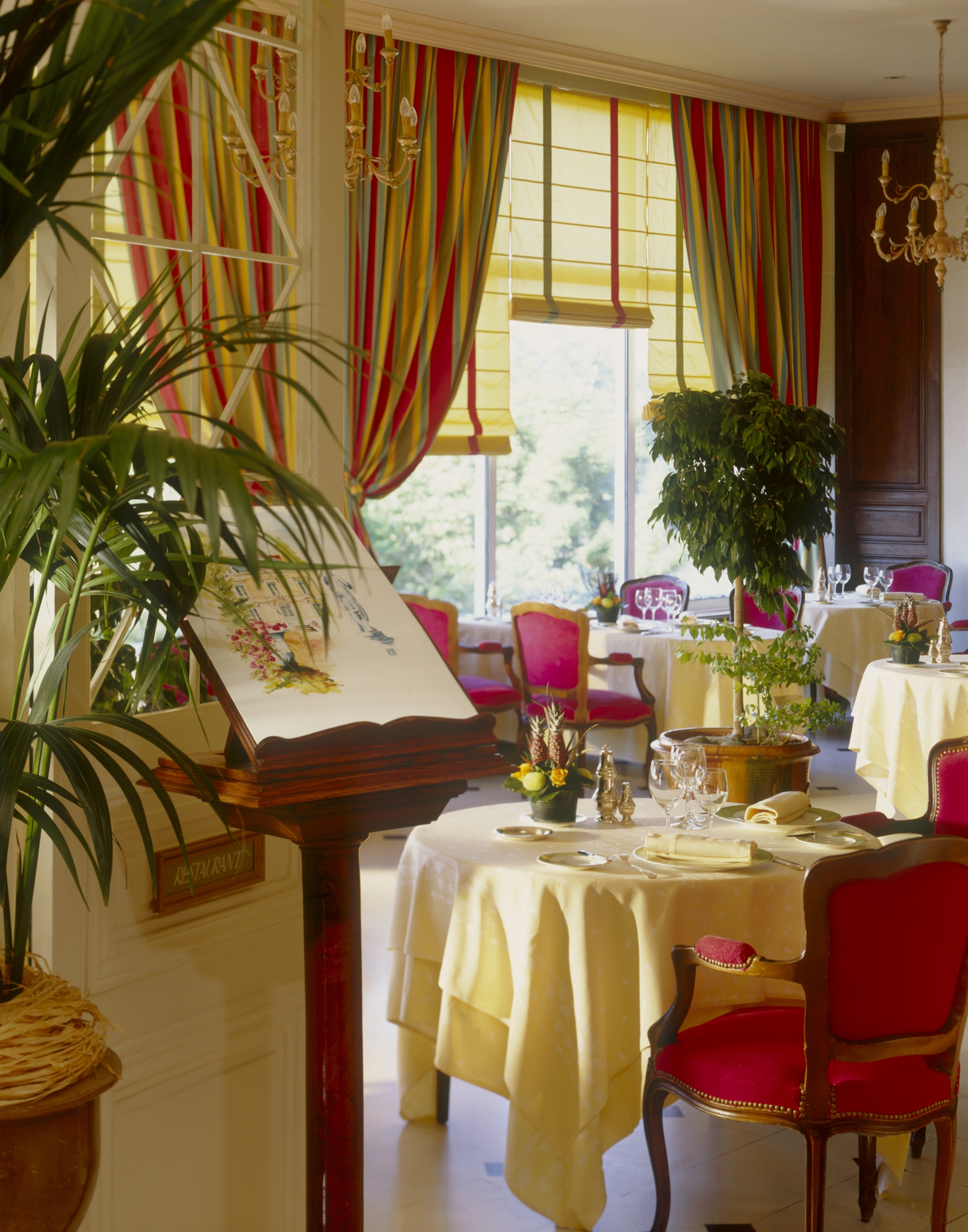 Entrance to restaurant with red arm chairs and tables set out