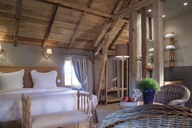Auberge de la Source Normandy charme superior bedroom wooden roof exposed beams wicker chairs and table 