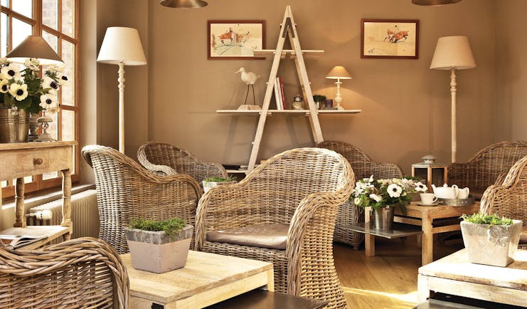 Auberge de la Source Normandy lounge area with brown wicker chairs