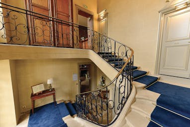 Reception with blue staircase spiraling round the corner 