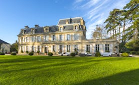 Yellow stone classical French chateau with lawns and trees Chateau la Cheneviere Normandy