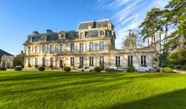 Yellow stone classical French chateau with lawns and trees Chateau la Cheneviere Normandy