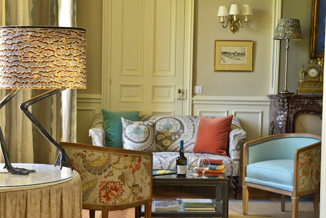 Lounge area with cushioned arm chairs, a fireplace and coffee table