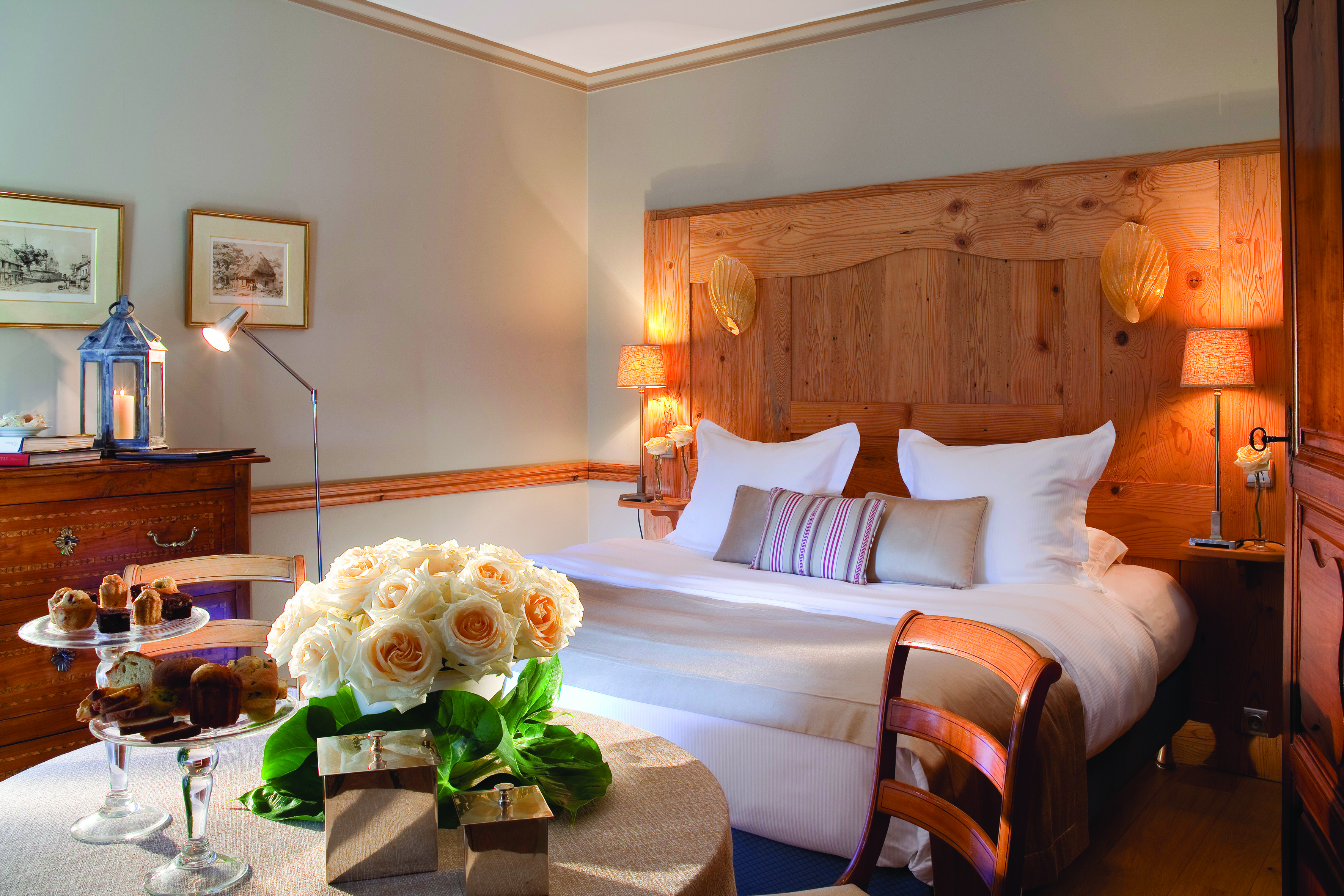 La Ferme Saint Simeon Normandy classic bedroom with wooden head board with shells table with flowers and pastries