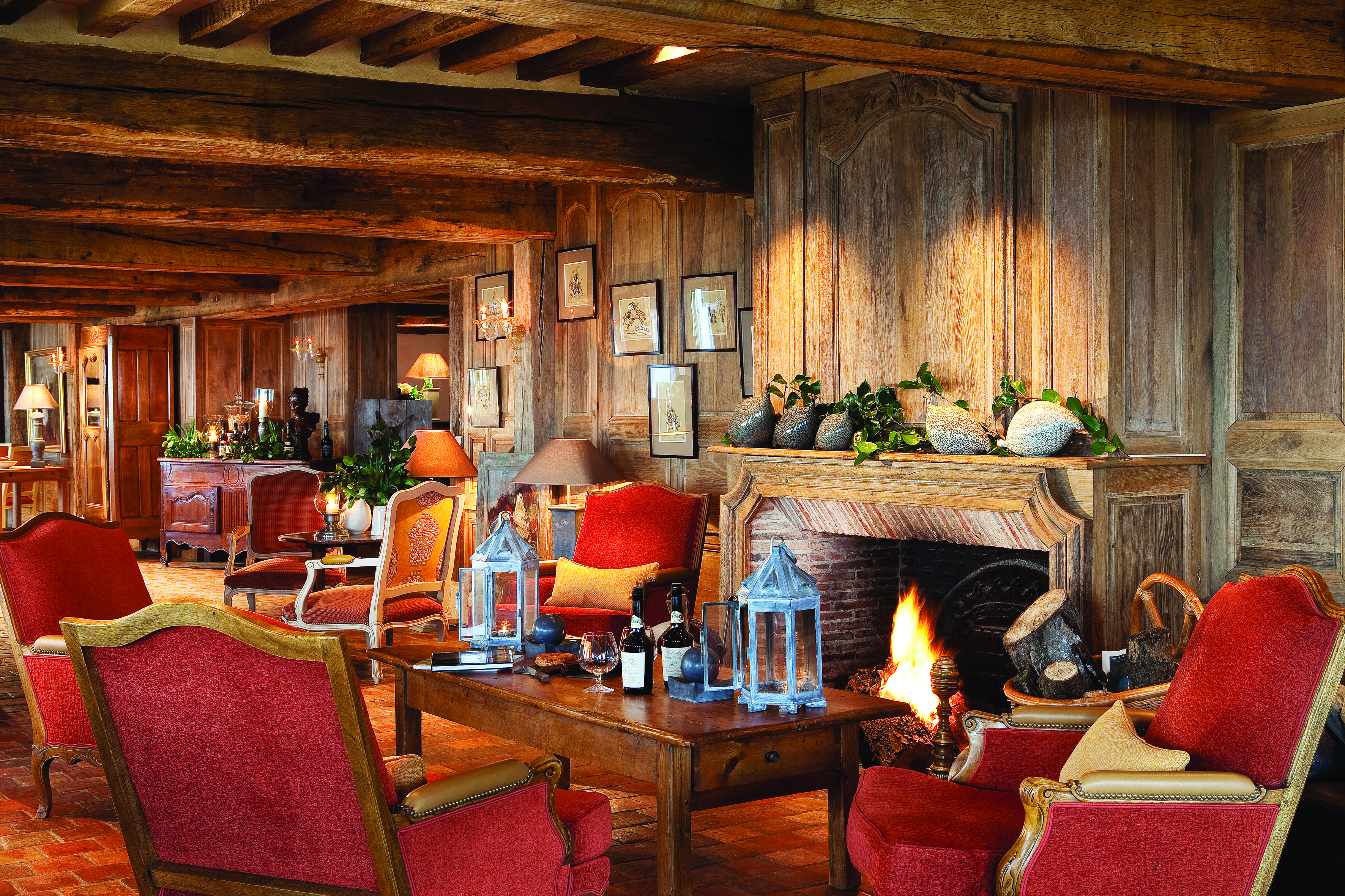 La Ferme Saint Simeon Normandy lounge area with wooden walls exposed beam and a fireplace