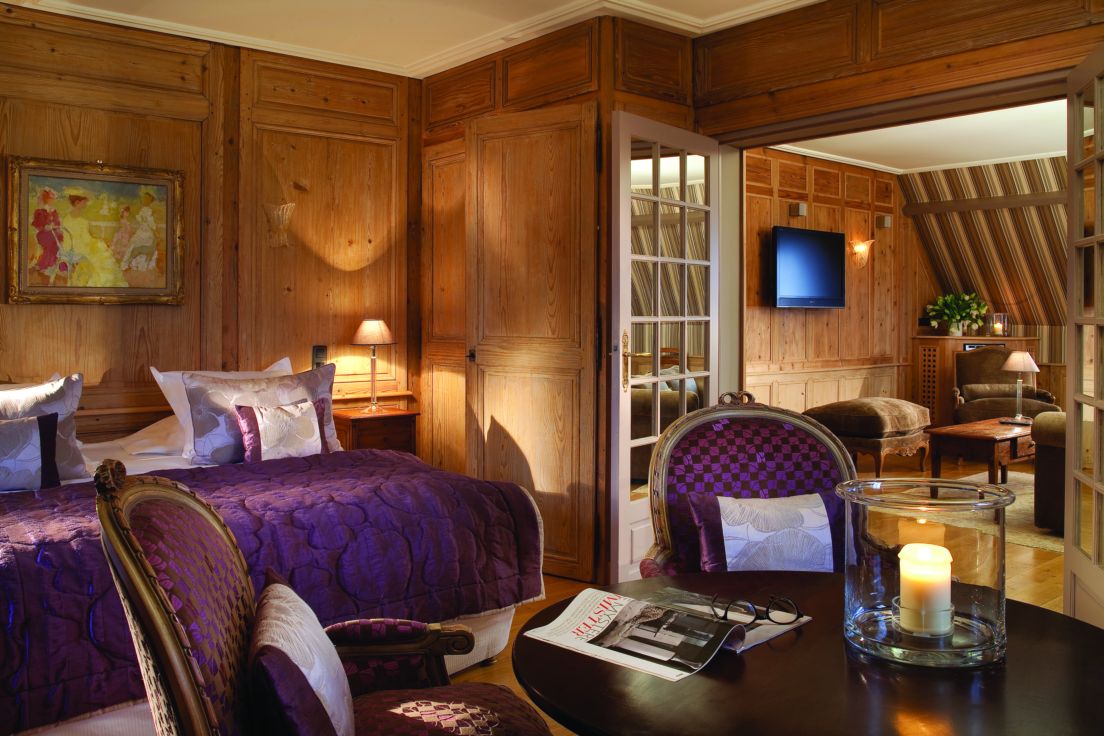 La Ferme Saint Simeon Normandy suite bedroom with wood panelled walls looking into a sitting room