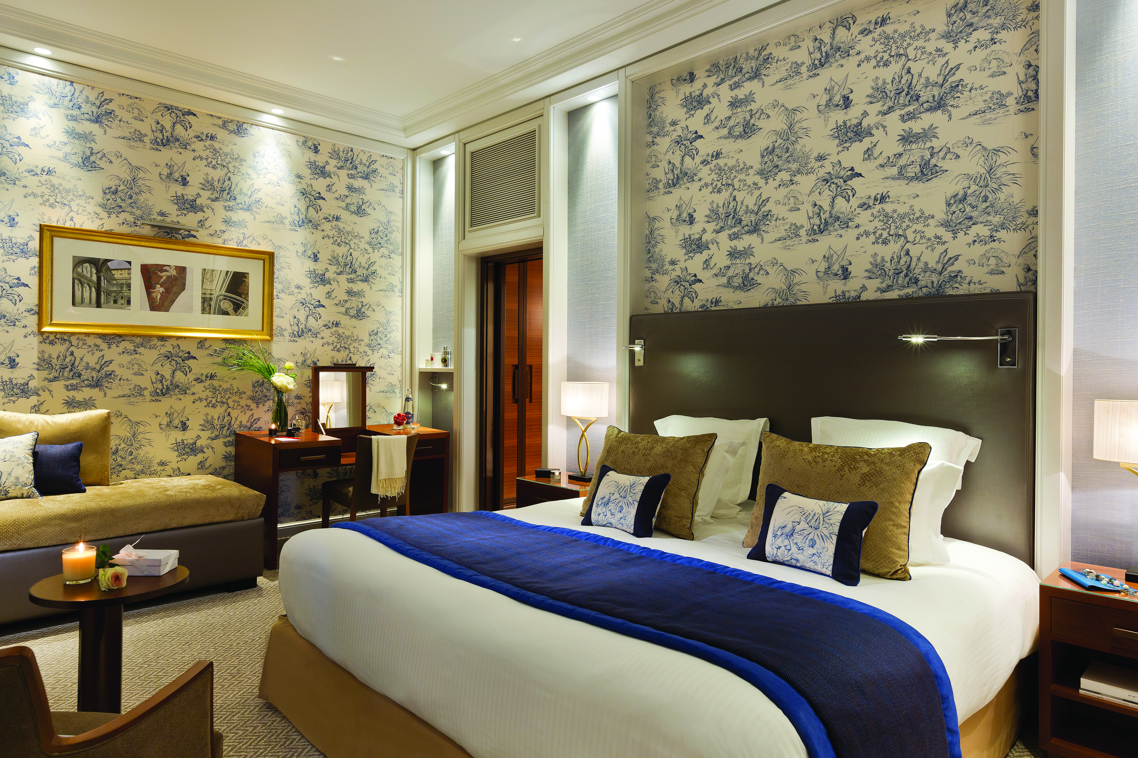 Hotel Normandy Barriere Normandy bedroom with blue and white wallpaper sofa and desk 